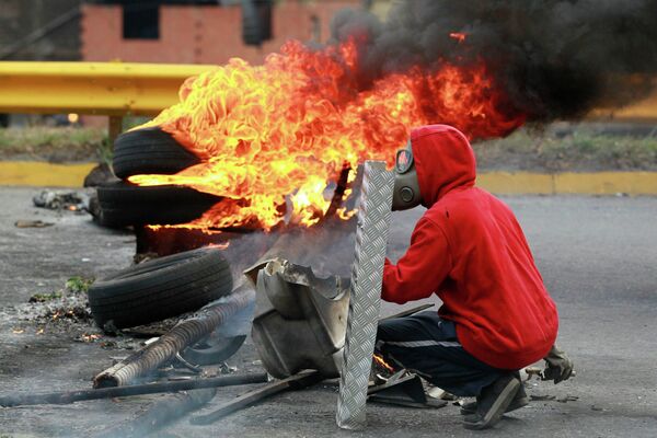 Протестующий во время акции протеста против правительства президента Мадуро в Каракасе