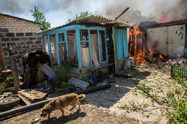 Горящие дома после массированного артиллерийского обстрела поселка Черевковка под Славянском