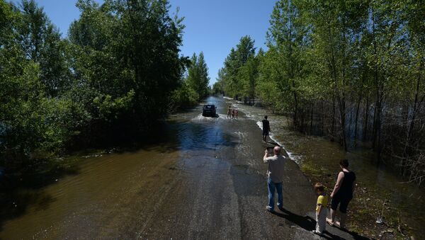 Жители стоят у затопленной дороги в микрорайон Затон города Барнаул. Архивное фото