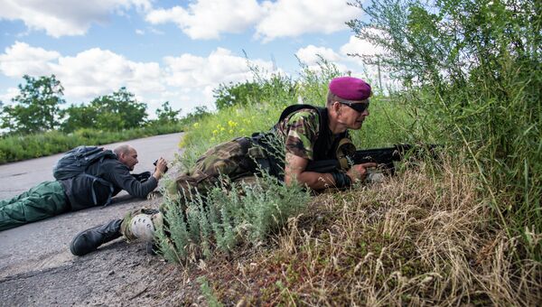 Журналист Комсомольской правды Дмитрий Стешин (слева) и командир отряда ополченцев с позывным Собр во время обстрела снайпером возле поселка Восточный. Архивное фото