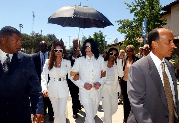 Майкл Джексон покидает здание суда вместе со своими сестрами Ла Тойей и Джанет. 2004