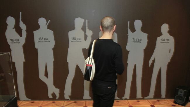 Посетитель у экспоната Фигуры актеров-исполнителей роли агента 007 Джеймса Бонда