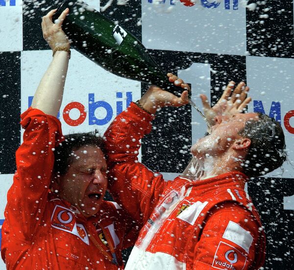 Немецкий автогонщик Михаэль Шумахер и менеджер команды Феррари после победы в Гран-при Франции