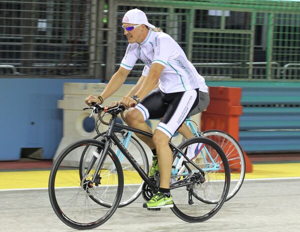 Немецкий автогонщик Михаэль Шумахер на велосипедной прогулке в Сингапуре