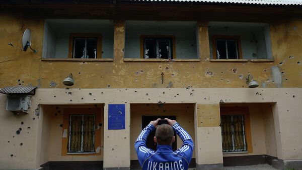 Местный житель фотографирует фасад здания министерства юстиции в Краматорске, которое подверглось артиллерийскому обстрелу украинской армией, архивное фото