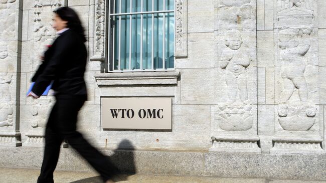 Женщина проходит возле здания ВТО в Женеве. Архивное фото