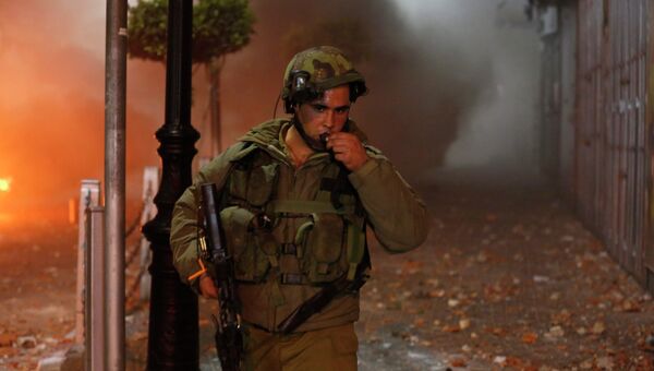 Израильский солдат после столкновений с палестинцами в Рамалле 22 июня 2014 г