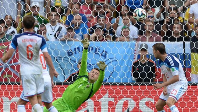 Вратарь сборной России Игорь Акинфеев (в центре) пропускает гол в матче группового этапа чемпионата мира по футболу 2014 между сборными командами Бельгии и России.