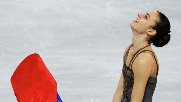 Аделина Сотникова с флагом России после выступления на Олимпийских играх в Сочи. Архивное фото