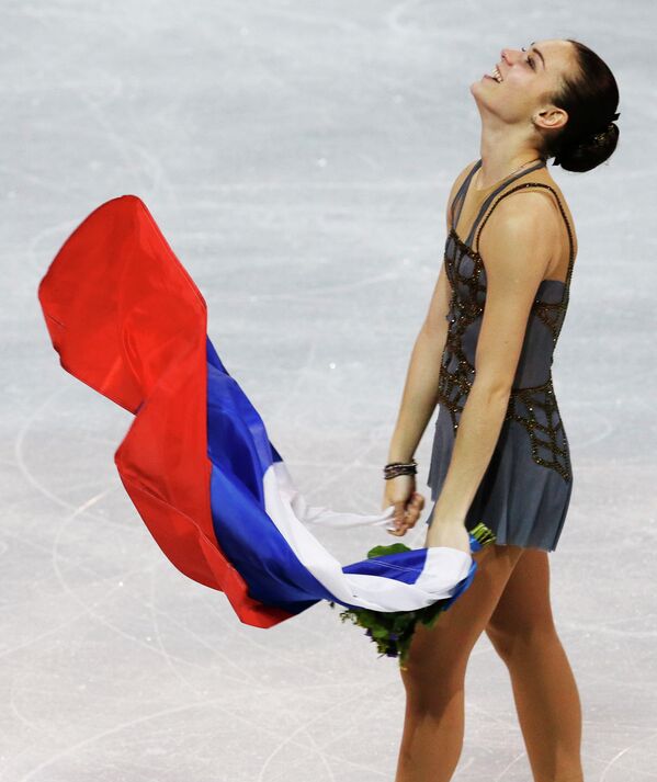 Аделина Сотникова с флагом России после выступления на Олимпийских играх в Сочи