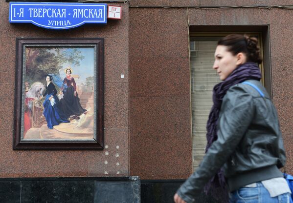 Женщина проходит мимо репродукции картины Карла Брюллова Портрет сестер Шишмаревых в центре Москвы
