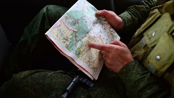Доброволец народного ополчения смотрит карту Луганской области