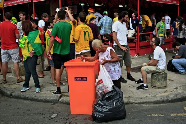Бразильская женщина у мусорного бака возле стадиона Маракана в Рио-де-Жанейро