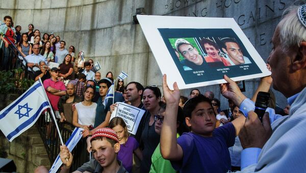 Ребенок держит портреты подростков, похищенных возле поселка на Западном берегу, возле здания штаб-квартиры ООН в Нью-Йорке