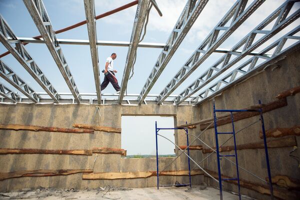 Рабочий на строительстве дома для пострадавших от наводнения 2013 года в селе Чигири Благовещенского района Амурской области