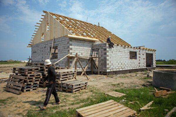 Рабочие на строительстве дома для пострадавших от наводнения 2013 года в селе Чигири Благовещенского района Амурской области