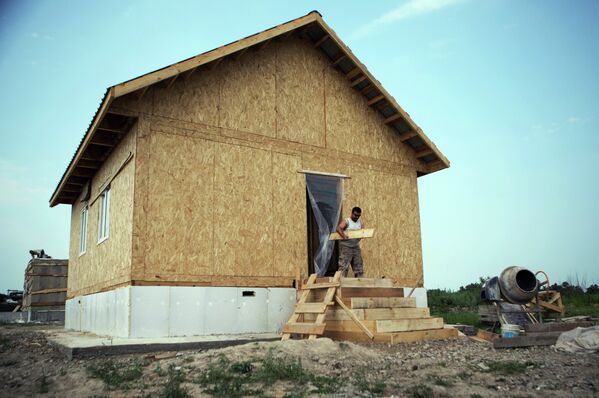 Рабочий на строительстве дома для пострадавших от наводнения 2013 года в селе Чигири Благовещенского района Амурской области