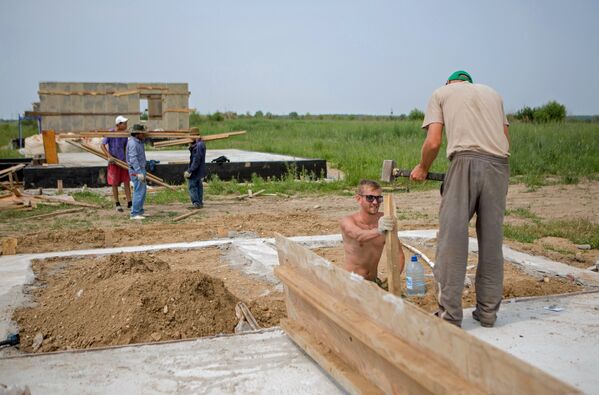 Рабочие на строительстве дома для пострадавших от наводнения 2013 года в селе Чигири Благовещенского района Амурской области