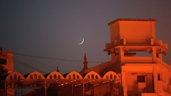 Полумесяц над мечетью после захода солнца в Карачи, Пакистан