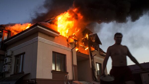 Загоревшийся в результате авиаобстрела дом в Николаевке, архивное фото