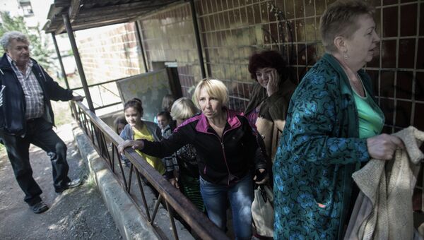Жители поселка Николаевка выходят из подвала, где они укрывались во время обстрела