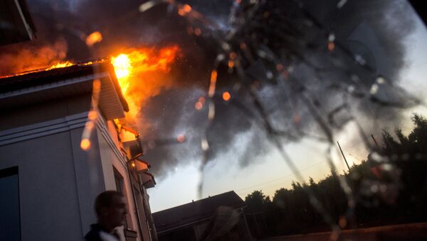 Загоревшийся в результате авиаобстрела дом в поселке Николаевка неподалеку от Луганска. Архивное фото