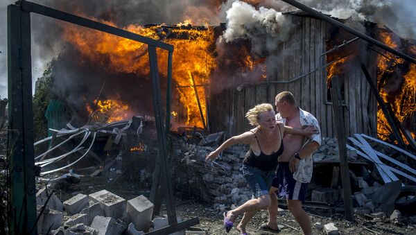 Местные жители спасаются от пожара, возникшего в результате авиационного удара вооруженных сил Украины по станице Луганская.