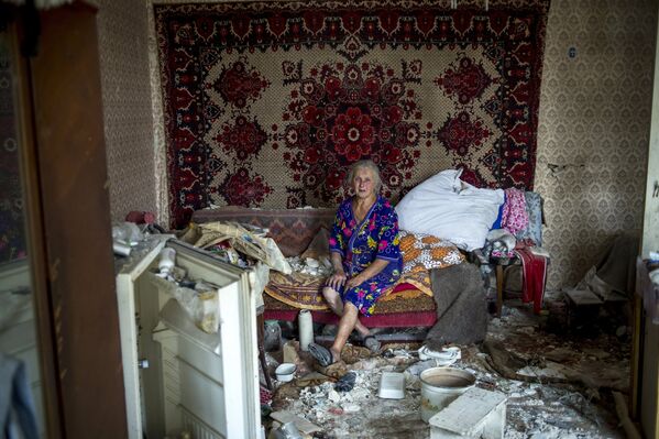 Местная жительница в своем доме, пострадавшем во время авиационного удара вооруженных сил Украины по станице Луганская