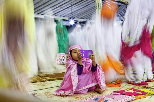 Девочка во время мусульманской молитвы в мечети в Индонезии