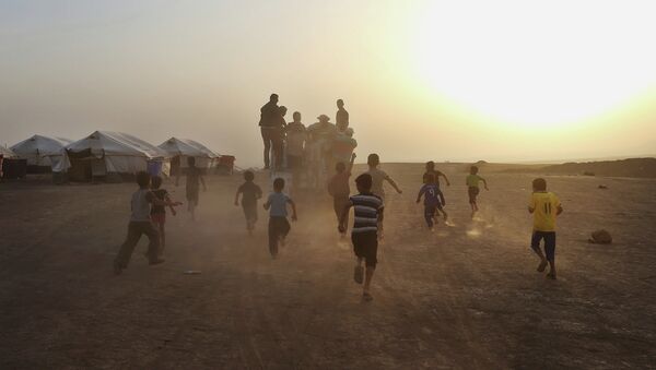 Дети бегут за грузовиком в лагере для беженцев на севере Ирака. Архивное фото