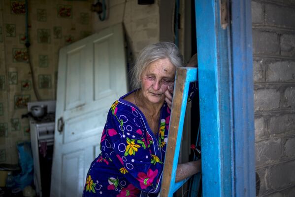 Местная жительница в своем доме, пострадавшем во время авиационного удара вооруженных сил Украины по станице Луганская. 2014 год