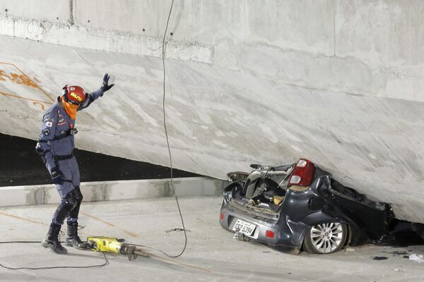 Легковой автомобиль под завалами, образовавшимися в результате обрушения эстакады в Бразилии