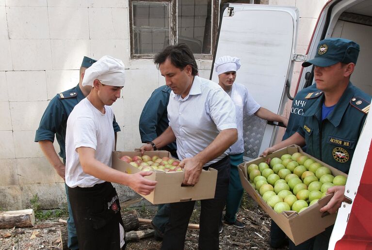 Разгрузка фургона с яблоками в лагере МЧС для беженцев в Симферополе