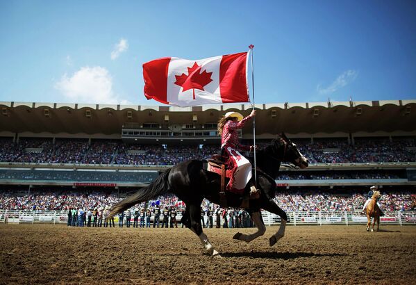 Девушка с флагом Канады во время ежегодного ковбойского родео-фестиваля Калгарийский Стампид