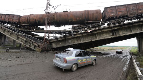 Автомобиль проезжает под взорванным железнодорожным мостом. Архивное фото