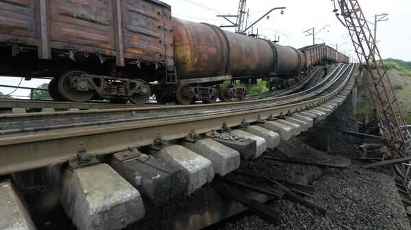 Провисший над взорванным железнодорожным мостом в Донецкой области грузовой состав. Архивное фото