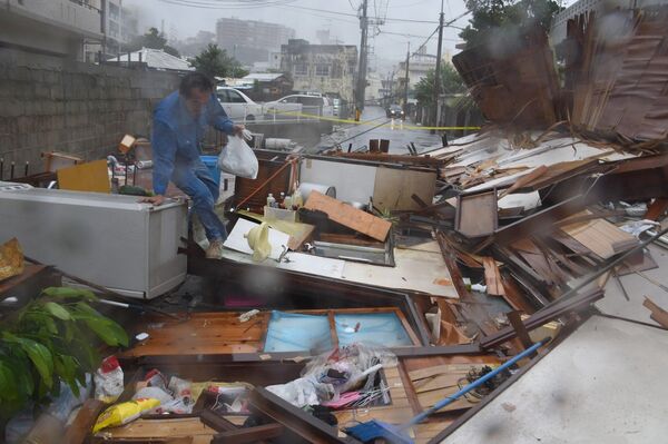 Житель пробирается через разрушения тайфуном Ногури, префектура Окинава, Япония