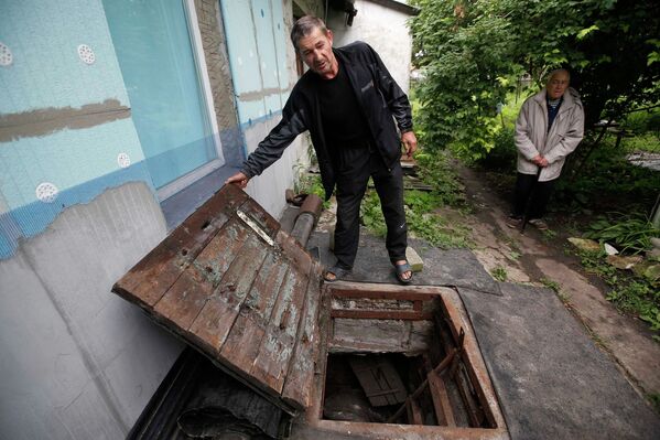 Житель Донецка показывает вход в подвал, который был его убежищем во время авиаудара