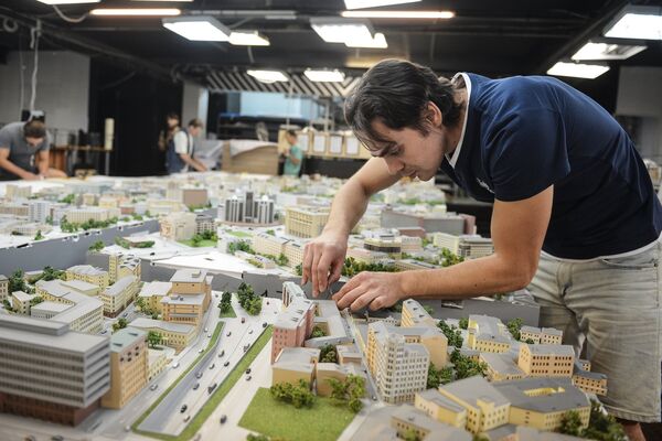 Художник работает во время демонстрации макета Москвы в архитектурно-строительном центре Дом на Брестской