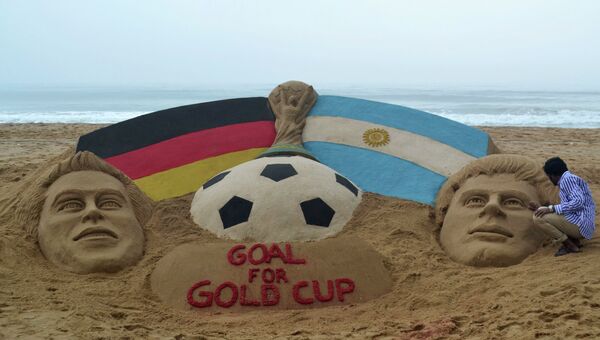 Песчаная скульптура на пляже в Индии, изображающая Кубок мира, а также капитана сборной Германии Филиппа Лама и капитана сборной  Аргентины Лионеля Месси