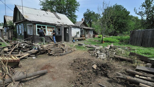 Воронка от попадания одного из фугасных снарядов на территорию частного жилого дома в городе Донецке Ростовской области. Архивное фото