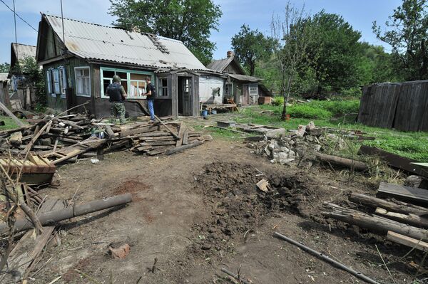 Воронка от попадания одного из фугасных снарядов на территорию частного жилого дома в городе Донецке Ростовской области
