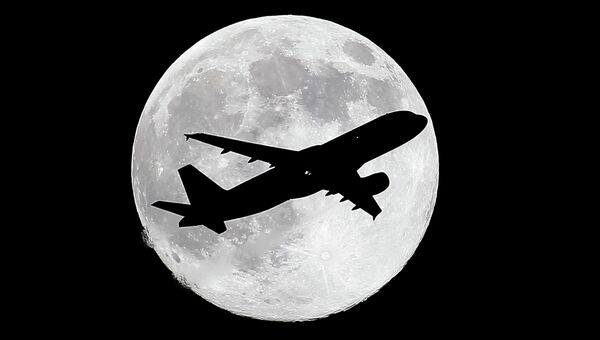 Лайнер идет за посадку в аэропорту Лос-Анджелеса на фоне луны за день до суперлуния