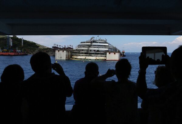 Туристы фотографируют затонувший круизный лайнер Коста Конкордия