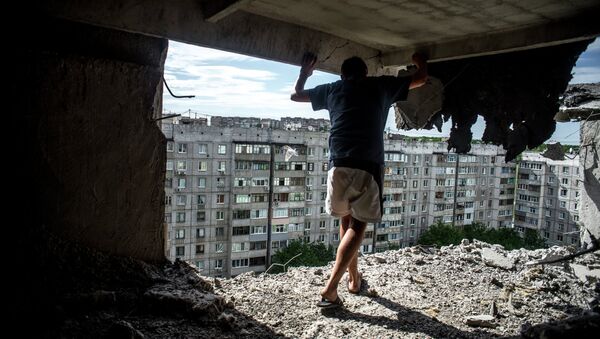 Мужчина в жилом доме, пострадавшем от артиллерийского обстрела в Луганске. Архивное фото