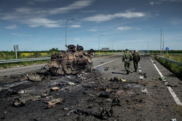 Бойцы ополчения у сожженной бронетехники украинской армии в поселке Роскошное