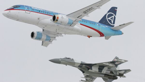 Самолет Sukhoi SuperJet-100 (вверху) в сопровождении истребителя Су-35 (внизу). Архивное фото