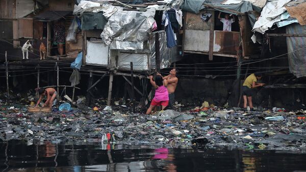 Жители города Манила, Филлипины, у своих жилищ во время тайфуна Раммасун