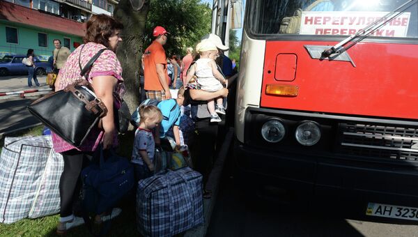 Жители Донецкой области садятся в автобус с беженцами, который отправляется из Донецка в Россию