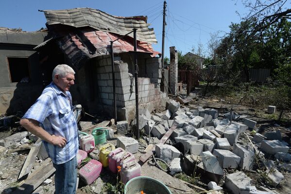 Житель Луганска у дома, разрушенного во время артиллерийского обстрела украинской армией